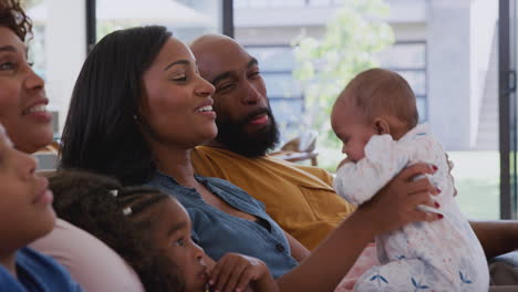 Mehrgenerationen-Afroamerikanerfamilie-Mit-Baby-Zu-Hause,-Die-Gemeinsam-Auf-Dem-Sofa-Sitzt-Und-Fernsieht
