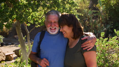 Portrait-Of-Loving-Senior-Hispanic-Couple-Hiking-Along-Trail-In-Countryside-Together