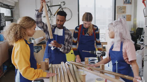 Multikulturelles-Team-In-Der-Werkstatt,-Das-Handgefertigte,-Nachhaltige-Bambus-Fahrradrahmen-Zusammenbaut