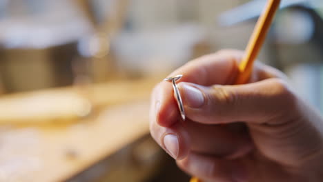 Close-Up-Of-Male-Jeweller-Working-On-Ring-Setting-In-Studio