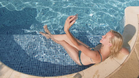 Woman-In-Bikini-Taking-Selfie-On-Mobile-Phone-In-Outdoor-Swimming-Pool-Then-Dropping-Phone-In-Water