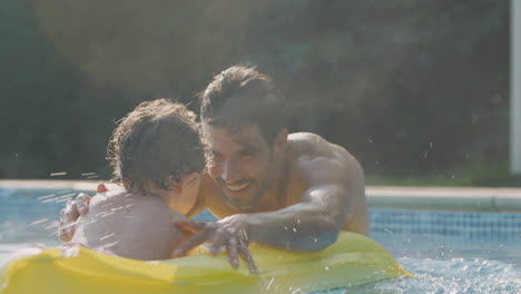 Vater-Und-Sohn-Vergnügen-Sich-Im-Sommerurlaub-Beim-Spielen-Auf-Einer-Aufblasbaren-Luftmatratze-Im-Freibad