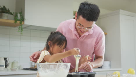 Padre-E-Hija-Asiáticos-Se-Divierten-Horneando-Pastelitos-Juntos-En-La-Cocina-De-Casa