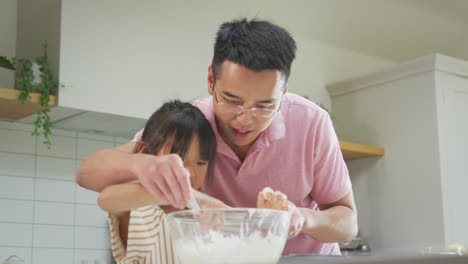 Padre-E-Hija-Asiáticos-Se-Divierten-Horneando-Pastelitos-Juntos-En-La-Cocina-De-Casa