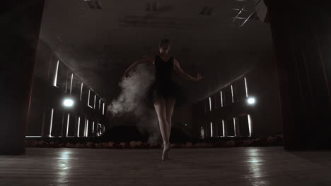 Una-Elegante-Bailarina-Bailando-Elementos-De-Ballet-En-La-Oscuridad-Con-Luz-Y-Humo-En-El-Fondo-En-Cámara-Lenta