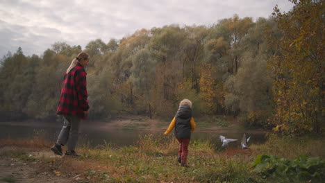 Kleiner-Junge-Und-Mutter-Spielen-Mit-Tauben-Im-Wald,-Fröhliche-Unterhaltung-Und-Spaß-Am-Naturwochenende-Am-Herbsttag