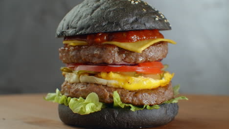 Black-burger.-With-greean-vegetable.-Black-Burger-On-Wooden-Table