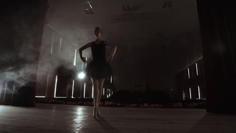 Prima-ballerina-on-pointes-training-on-stage-with-spotlights-in-late-evening-before-important-performance-in-Opera-and-Ballet-theatre.