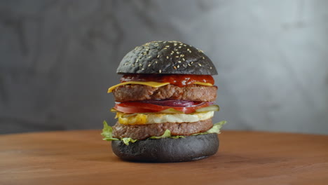 Burger-Oder-Hamburger-Mit-Schwarzbrot-Auf-Einem-Unscharfen-Hintergrund-Aus-Blättern