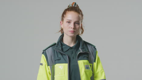 Studio-Portrait-Of-Serious-Young-Female-Paramedic-Against-Plain-Background