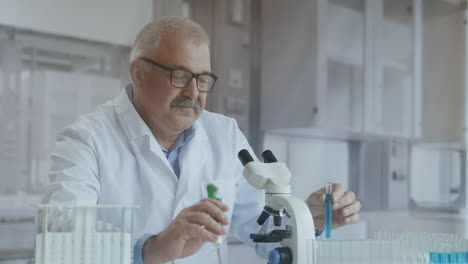 Laboratory.-Hand-in-blue-glove-moves-the-tubes-and-drips-blue-liquid.-Medical-worker-holding-yellow-and-blue-liquid-sample-in-test-tube-analyzing-urine-in-lab.-High-quality-4k-footage