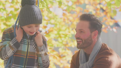 Vater-Schubst-Sohn-Und-Hat-Spaß-Auf-Seilschaukel-Im-Herbstgarten