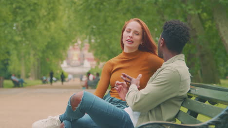 Young-Couple-Of-Vloggers-Or-Social-Influencers-Travelling-Through-City-Park-For-Social-Media