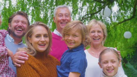 Portrait-Of-Smiling-Multi-Generation-Family-At-Home-In-Garden-Together