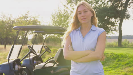 Portrait-Of-Female-Golfer-Standing-By-Buggy-On-Golf-Course