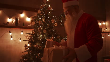 On-Christmas-night-Santa-delivers-gifts-to-homes-while-everyone-is-asleep.-Santa-will-leave-gifts-under-the-Christmas-tree-in-the-decorated-house.-High-quality-4k-footage