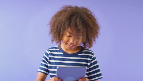 Retrato-De-Estudio-De-Niño-Usando-Tableta-Digital-Contra-Fondo-Púrpura