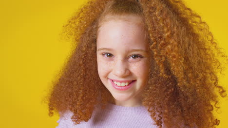 Studioporträt-Eines-Lächelnden-Mädchens-Mit-Roten-Haaren-Vor-Gelbem-Hintergrund
