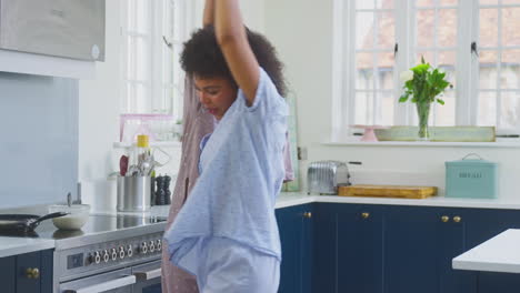 Schwangeres-Gleichgeschlechtliches-Paar-Tanzt-Und-Macht-Morgenpfannkuchen-In-Der-Küche