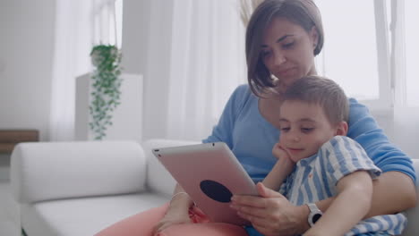 Madre-E-Hijo-Jugando-Con-Tableta-Digital-En-Casa.-Madre-Joven-Con-Sus-5-Años-Sonriendo-Con-Tableta-Digital-En-Casa