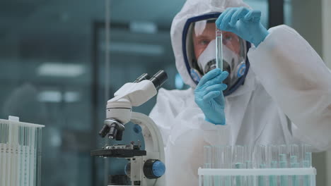 medical-expert-is-testing-toxic-medicament-in-laboratory-dressed-in-protective-gown-and-respirator-mask-development-of-new-drug-pharmaceutical-producing