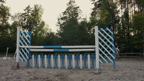 Young-woman-on-horse-jumping-over-obstacles.-Slow-motion.-Training-horses-before-the-competition.-Horse-Racing.-Horse-breeding.-Farm.-Horseman.-Rider-equestrian-jockey