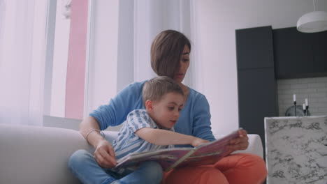 Madre-E-Hijo-Leen-Libros.-Feliz-Joven-Madre-E-Hijo-Leen-Libros-En-El-Sofá-De-Casa