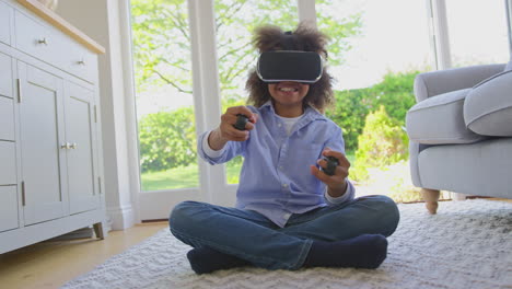 Boy-Sitting-On-Floor-In-Lounge-Wearing-VR-Headset-Playing-Shooting-Computer-Game