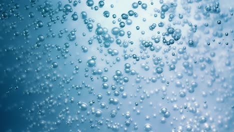 Many-water-bubbles-in-blue-water-close-up,-abstract-water-wave-with-bubbles-in-slow-motion.