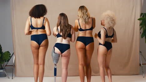 Rear-View-Of-Women-Friends-One-With-Prosthetic-Limb-In-Underwear-Promoting-Body-Positivity-Dancing