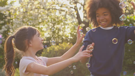 Lächelnde-Jungen-Und-Mädchen-Im-Freien,-Die-Spaß-Beim-Spielen-Mit-Blasen-Im-Garten-Haben