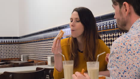 Hombre-Y-Mujer-Bebiendo-Horchata-Con-Fartons-Y-Churros