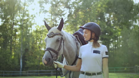 Woman-prepares-her-white-horse-for-horse-racing.-It's-wonderful-walk-before-professional-horse-riding-in-the-nature.