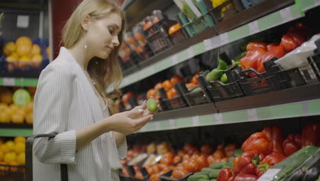 Mujer-Chica-En-El-Supermercado-Compra-Verduras.-La-Mujer-Elige-Pepinos.-Manos-De-Mujer-Tomando-Tomates-Rojos-En-El-Supermercado.-Selección-De-Cerca-Eligiendo-Pepinos-Vegetales.-Cesta-De-Compras-Saludables.