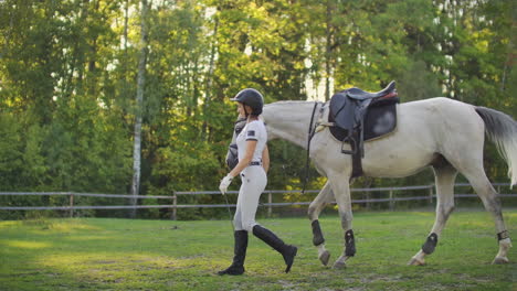 Horsewomen-is-walking-with-her-horse-before-horse-racing-in-the-horse-club.-It's-enjoyable-walk-in-nature