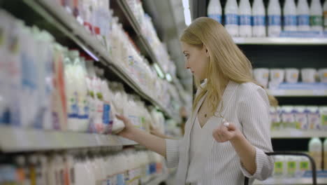 woman-choosing-and-buying-fresh-organic-dairy-products-at-grocery-store