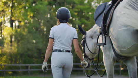 Women-with-horse-on-the-walk-in-the-horse-club.-They-are-walking-together-in-nature-women-leads-her-horse.