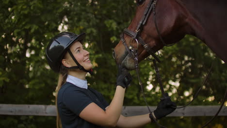 Girl-stroking-her-horse-after-training-in-the-horse-club.-Horsewoman-likes-her-horse-and-showing-devotion-and-care.