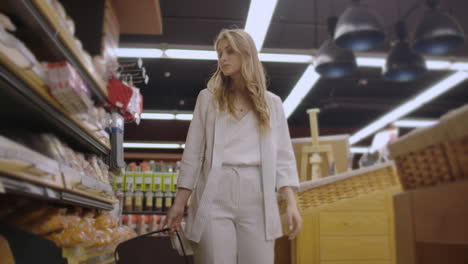 sale-shopping-consumerism-and-people-concept---happy-young-woman-choosing-and-reading-label-on-bread-in-market