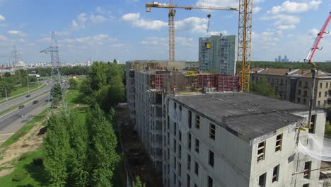 Aerial-view-of-unfinished-apartment-house-with-builders-working