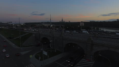 Moskauer-Stadtbild-In-Der-Abenddämmerung-Verkehr-Auf-Auto--Und-Eisenbahnbrücken-Aus-Der-Luft