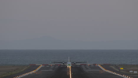 Avión-De-Pasajeros-Que-Sale-Del-Aeropuerto-Por-Mar-Por-La-Noche.