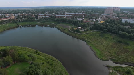 Vista-Aérea-De-La-Ciudad-Con-Fábrica-En-La-Orilla-Del-Cuerpo-De-Agua