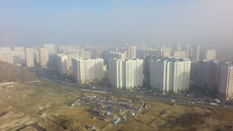 Una-Vista-Aérea-De-Un-Gran-Sitio-De-Construcción-Y-Una-Zona-Residencial-Detrás-De-él