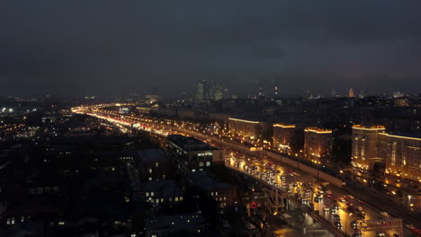 Eine-Luftaufnahme-Einer-Nächtlichen-Stadt-Mit-Einer-Stark-Befahrenen-Autobahn