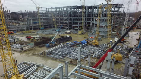 An-aerial-view-of-a-busy-construction-site-filled-with-cranes-building-frames-and-metal-beams