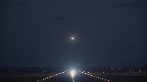 Una-Vista-Nocturna-De-Una-Pista-Con-Un-Avión-Despegando.