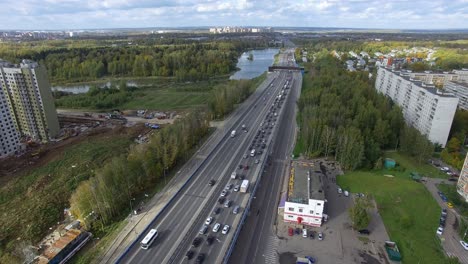 Eine-Luftaufnahme-Einer-Endlosen-Autobahn-Mit-Viel-Verkehr-Inmitten-Der-Grünen-Stadtlandschaft