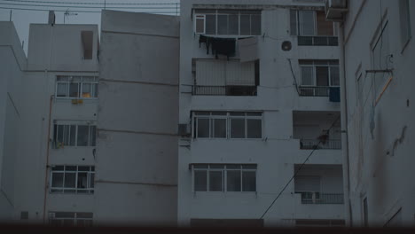 Apartment-block-with-shutters-on-windows-evening-view