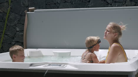 Mamá-Con-Niños-Disfrutando-Del-Tiempo-En-El-Jacuzzi-Al-Aire-Libre